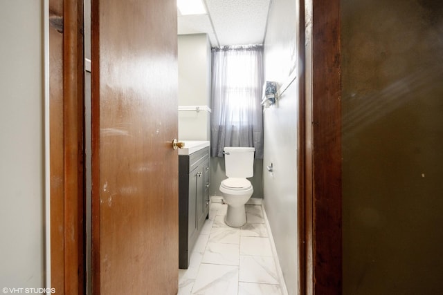 bathroom featuring a textured ceiling, toilet, and vanity