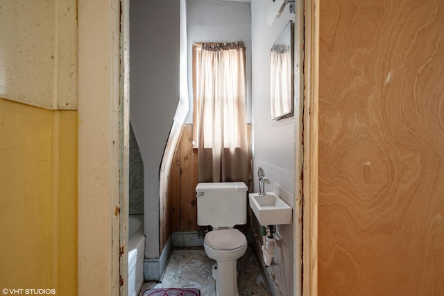 bathroom featuring toilet, a washtub, and sink