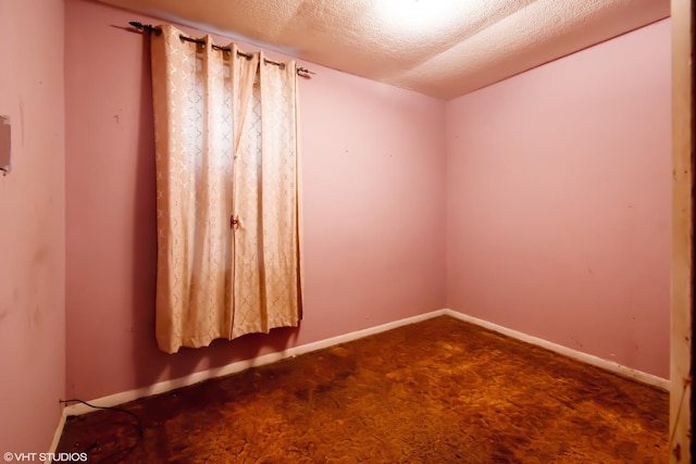 carpeted empty room featuring a textured ceiling