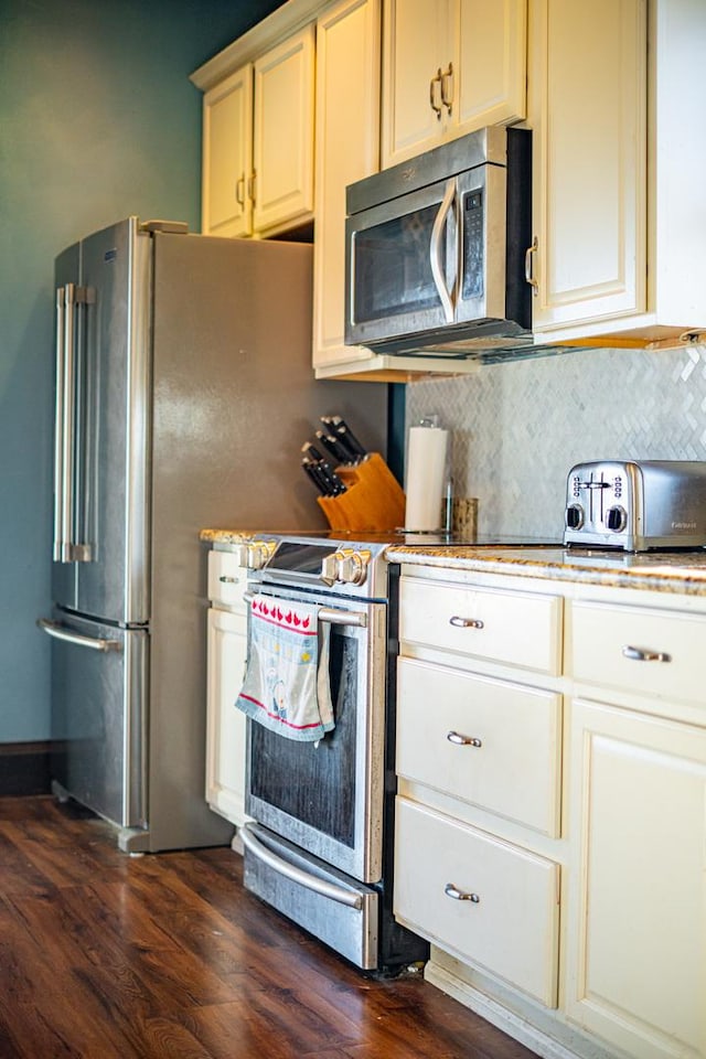 kitchen with tasteful backsplash, stainless steel appliances, and dark wood-type flooring