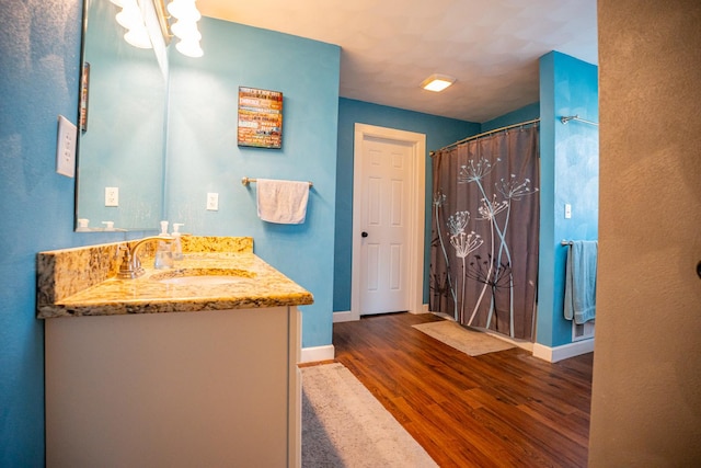 bathroom featuring vanity, wood-type flooring, and walk in shower