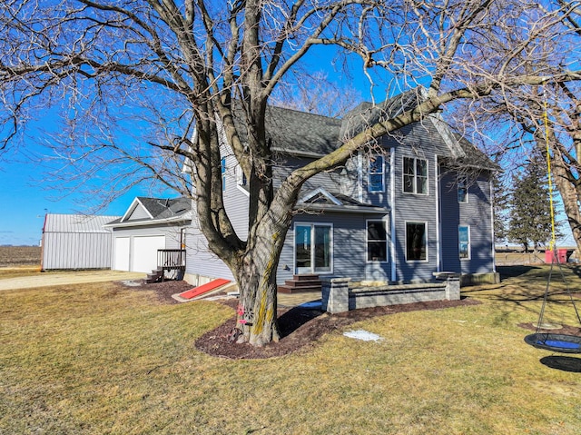 back of house with a garage and a lawn