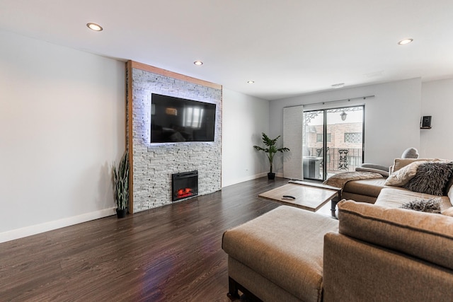 living room with a fireplace and dark wood-type flooring