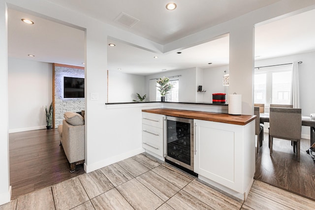 kitchen with white cabinets, butcher block counters, and wine cooler