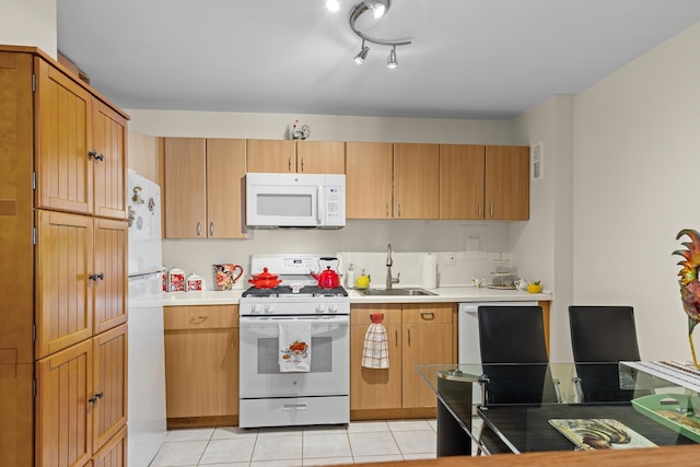 kitchen featuring sink, light tile patterned flooring, and white appliances