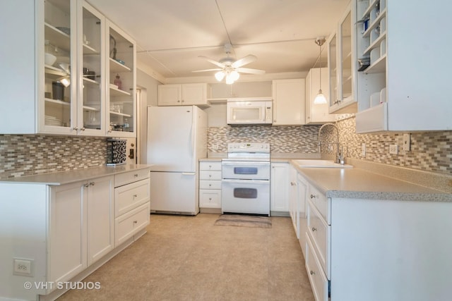 kitchen with white appliances, white cabinetry, and sink