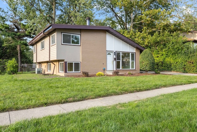 view of side of property with a yard and central AC unit