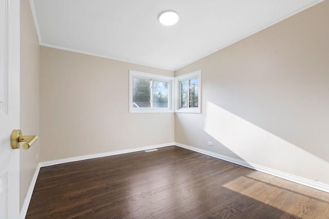 spare room featuring ornamental molding and dark wood-type flooring