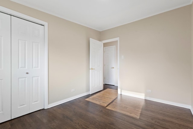 unfurnished bedroom with a closet and dark hardwood / wood-style flooring