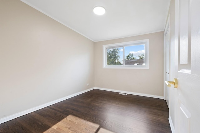 empty room featuring crown molding and dark wood-type flooring