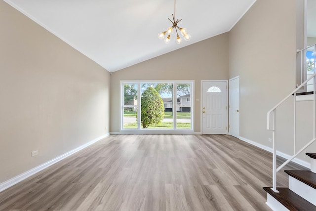 foyer featuring light hardwood / wood-style flooring, a high ceiling, and an inviting chandelier