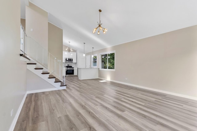 unfurnished living room featuring high vaulted ceiling, light hardwood / wood-style flooring, and a notable chandelier