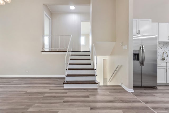 stairway with wood-type flooring and sink