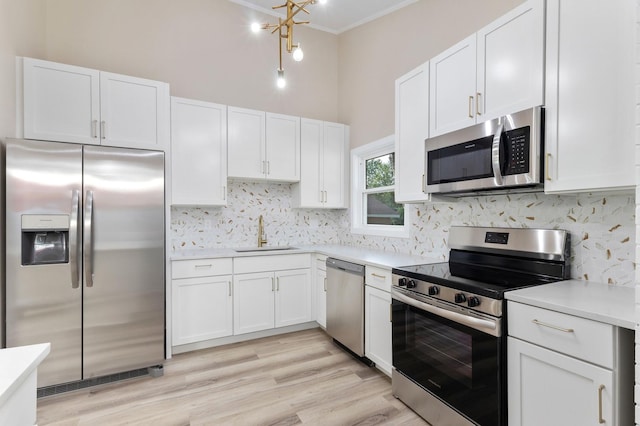 kitchen with stainless steel appliances, white cabinetry, and sink