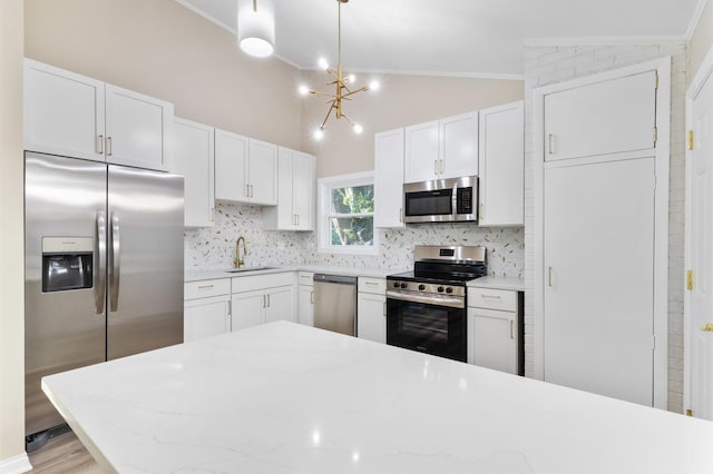 kitchen with sink, tasteful backsplash, decorative light fixtures, white cabinets, and appliances with stainless steel finishes