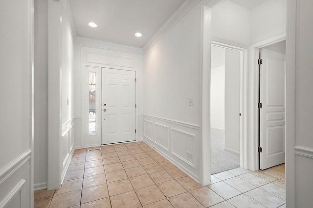 foyer with ornamental molding and light tile patterned flooring