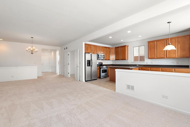 kitchen featuring a notable chandelier, stainless steel appliances, light colored carpet, and hanging light fixtures