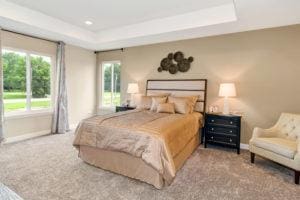 carpeted bedroom with a tray ceiling