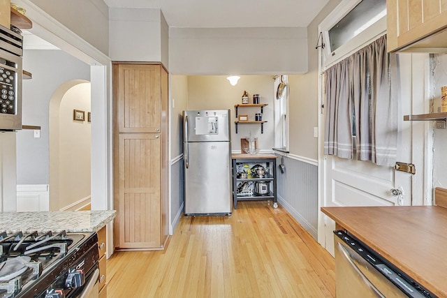 kitchen featuring stainless steel appliances, light wood-type flooring, and light brown cabinets