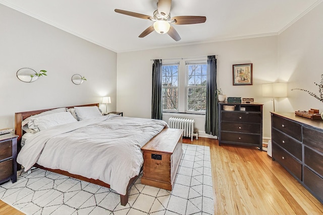 bedroom featuring ceiling fan, light wood-type flooring, radiator heating unit, and crown molding