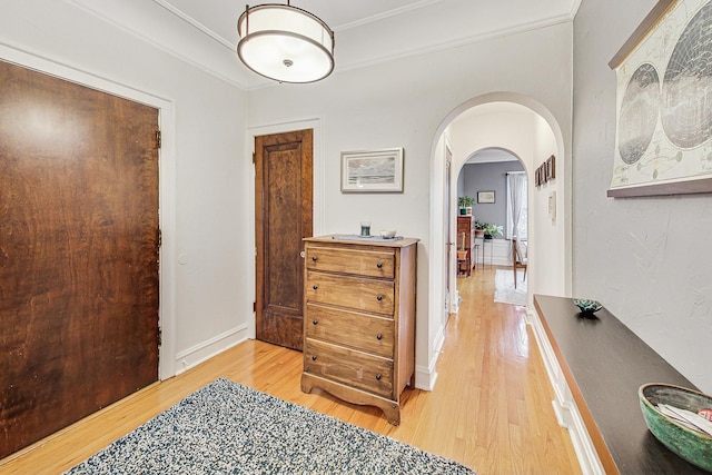 corridor featuring light wood-type flooring and crown molding