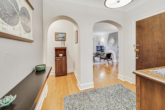 foyer entrance featuring light hardwood / wood-style floors and crown molding