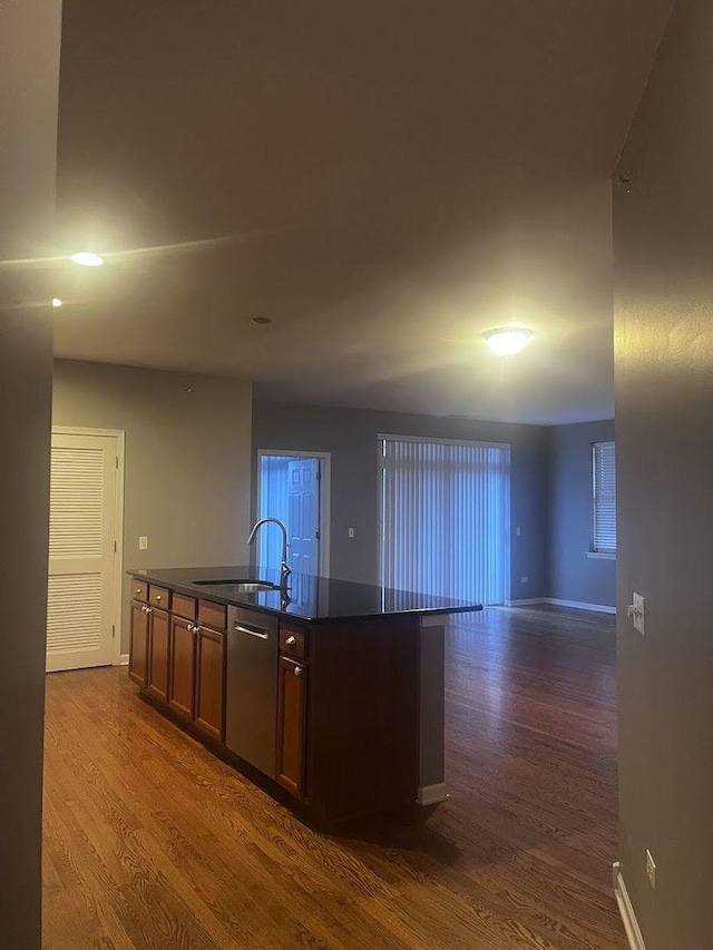 kitchen featuring dark hardwood / wood-style flooring, sink, an island with sink, and stainless steel dishwasher