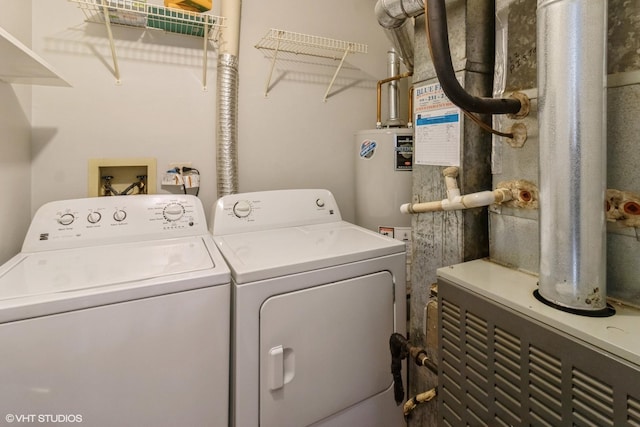 laundry area featuring gas water heater, heating unit, and washer and clothes dryer