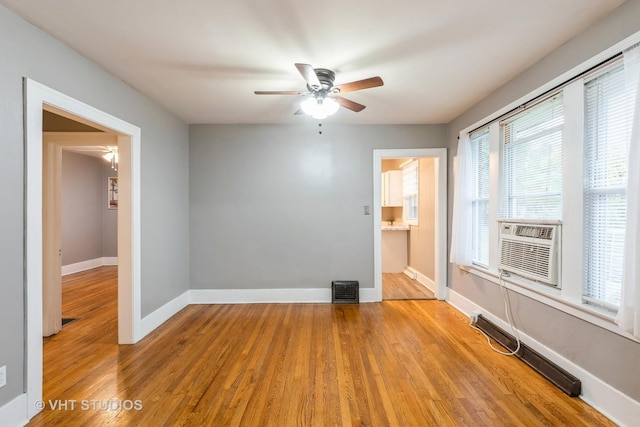 unfurnished room featuring ceiling fan, cooling unit, and light wood-type flooring