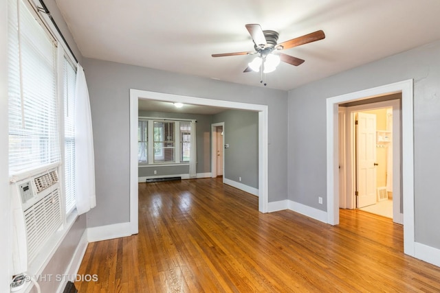 unfurnished room with wood-type flooring, a baseboard radiator, and ceiling fan