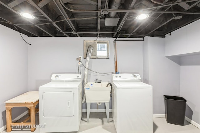 clothes washing area with separate washer and dryer and sink