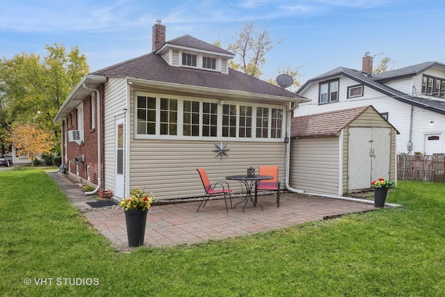 rear view of house with a patio area, a yard, cooling unit, and a storage unit