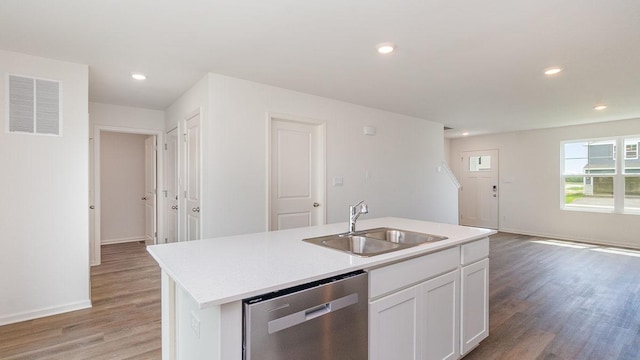 kitchen with white cabinetry, sink, light hardwood / wood-style flooring, stainless steel dishwasher, and an island with sink