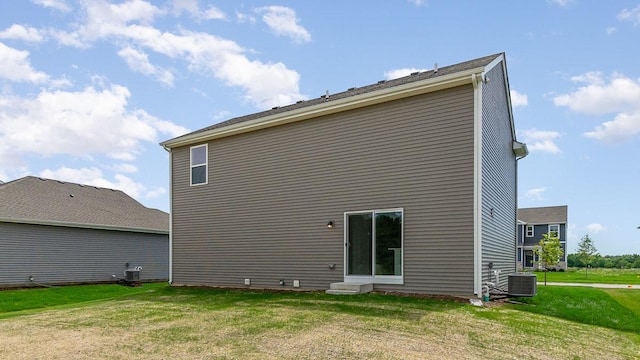 back of house with a yard and central air condition unit