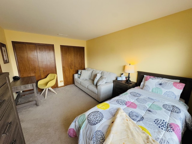 carpeted bedroom featuring two closets