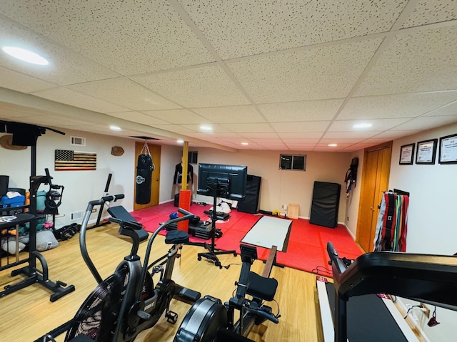 workout room featuring hardwood / wood-style flooring and a drop ceiling