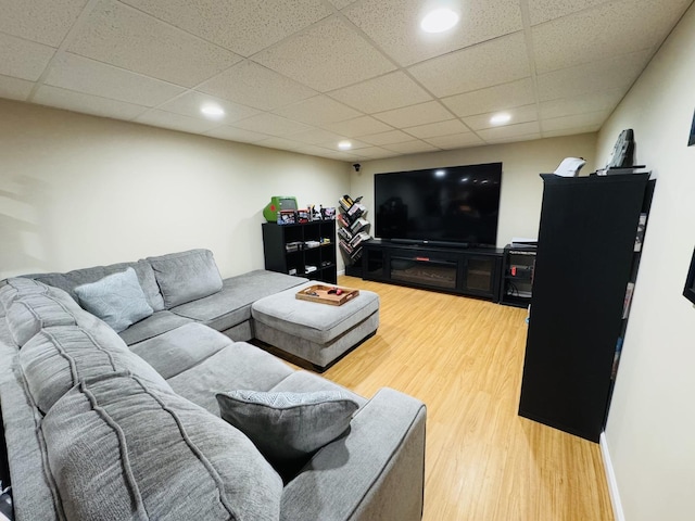 living room featuring hardwood / wood-style flooring and a drop ceiling