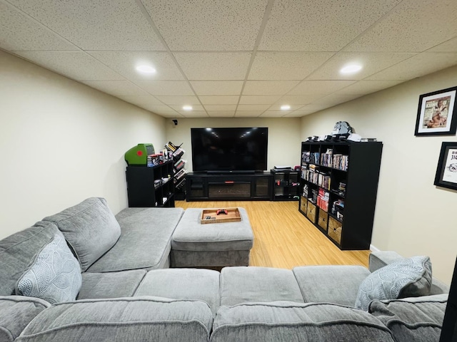 living room with a paneled ceiling and light hardwood / wood-style floors