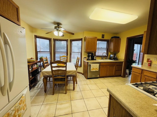 kitchen featuring light tile patterned flooring, sink, stainless steel dishwasher, ceiling fan, and white fridge