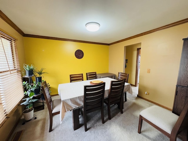 dining space with carpet floors and crown molding