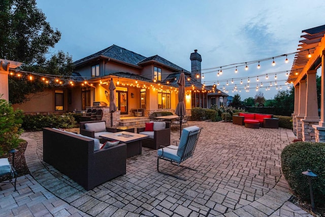 patio terrace at dusk with an outdoor living space with a fire pit