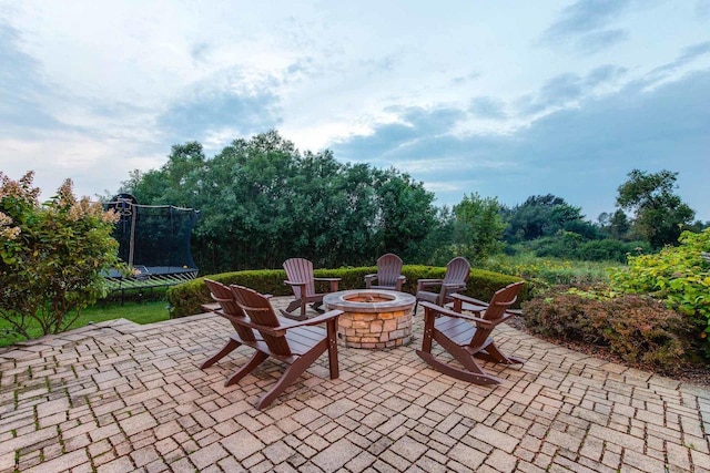 view of patio featuring an outdoor fire pit and a trampoline