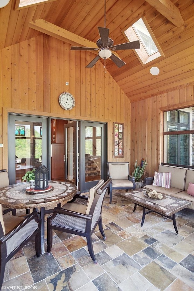 interior space featuring ceiling fan, wood ceiling, and vaulted ceiling with skylight