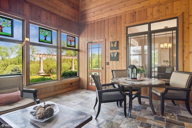 sunroom featuring a chandelier and lofted ceiling