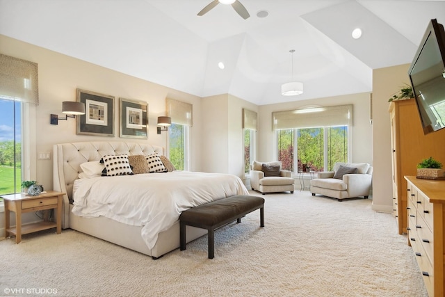 bedroom with ceiling fan, vaulted ceiling, light carpet, and multiple windows