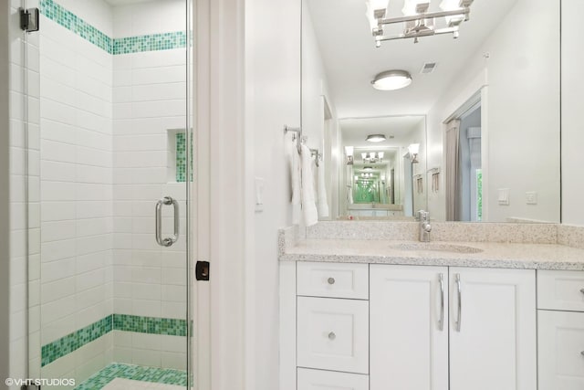 bathroom featuring vanity and a shower with shower door