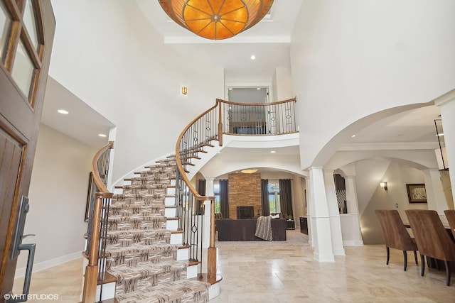 entrance foyer featuring a towering ceiling and a stone fireplace