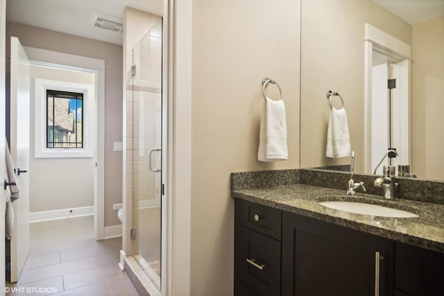 bathroom featuring tile patterned flooring, vanity, and an enclosed shower