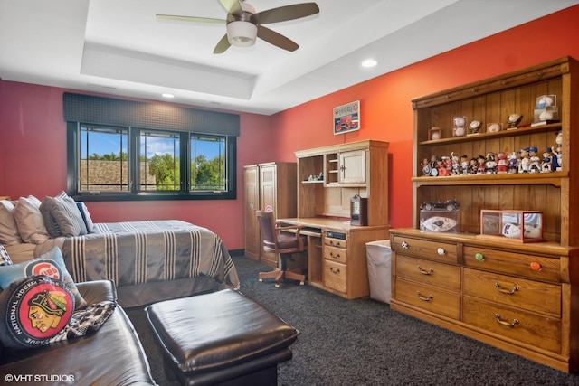 carpeted bedroom featuring a raised ceiling and ceiling fan