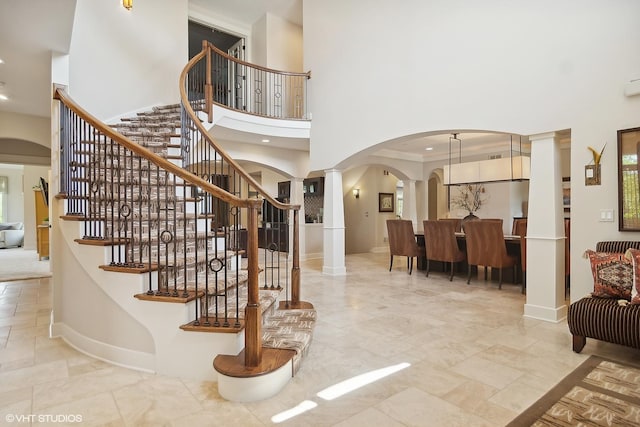 foyer entrance with a towering ceiling and ornate columns